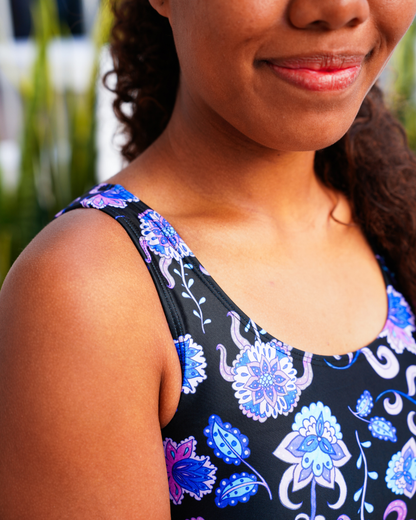 Close-up of a woman wearing a black sleeveless teen bikini with a blue, purple, and white floral paisley pattern.