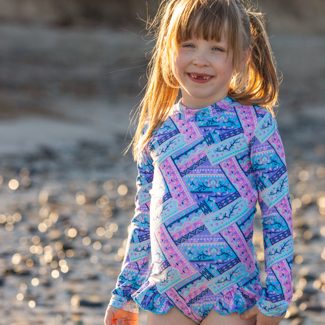 Young girl wearing a swimsuit for tweens on a beach.